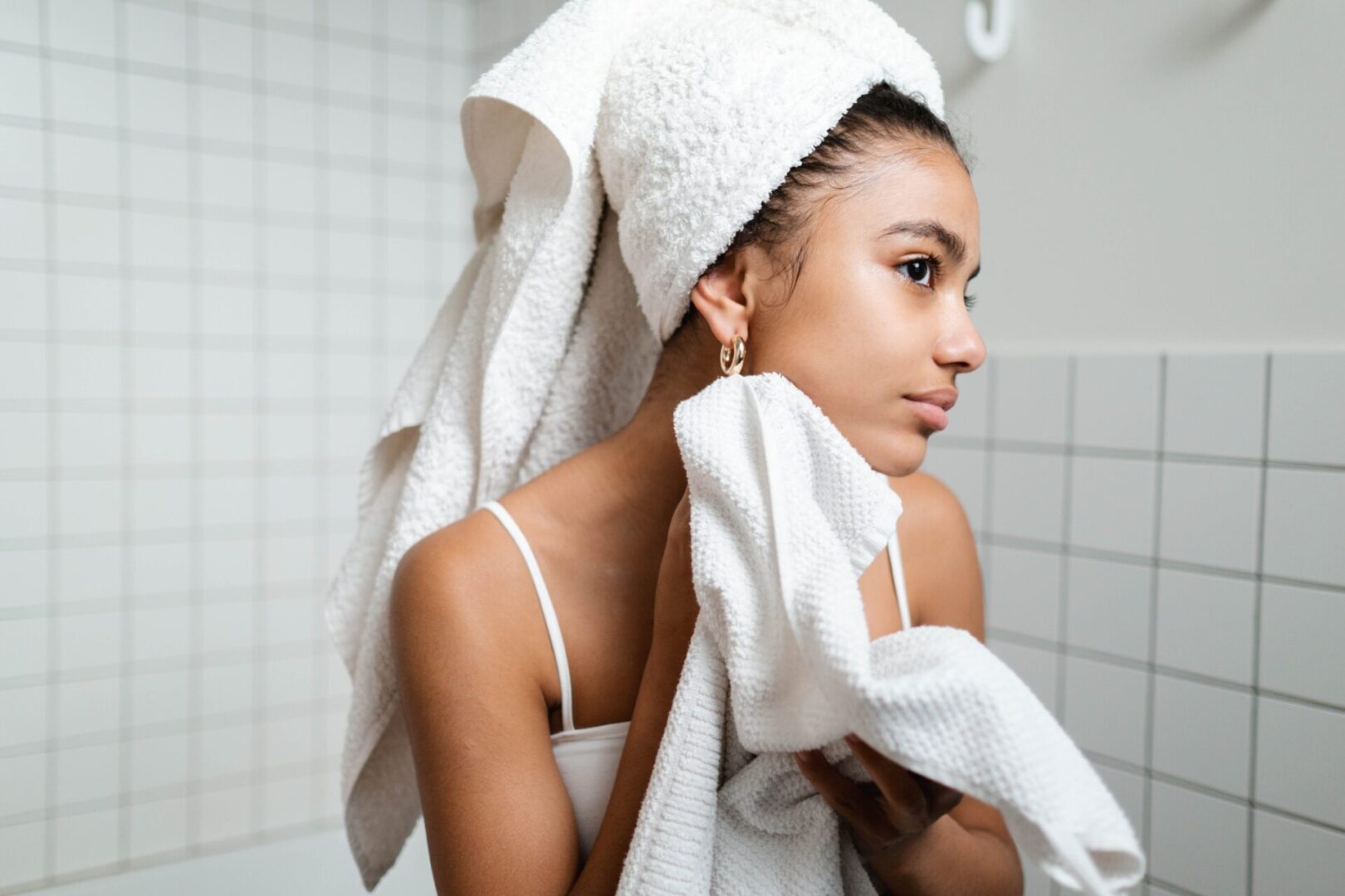 A woman in white towel holding her hair.