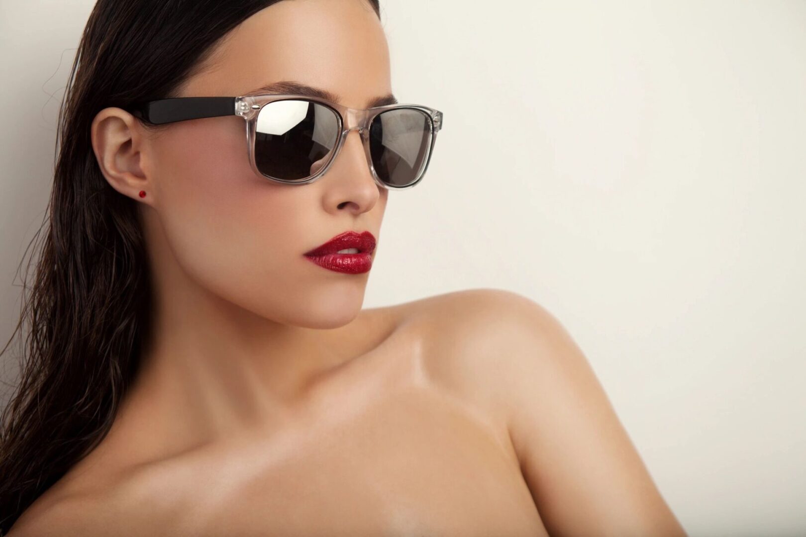 A woman with red lipstick and sunglasses on her head.