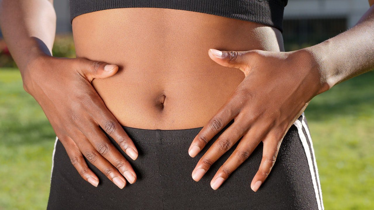 A person is holding their stomach and hands